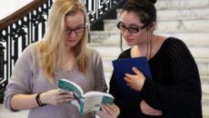 Two students looking at book